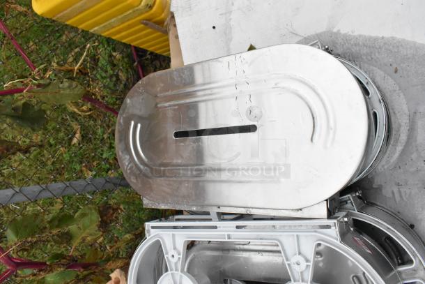 Stainless steel toilet paper dispensers, stack of multiple units, visible wear, part of 9-item auction lot.