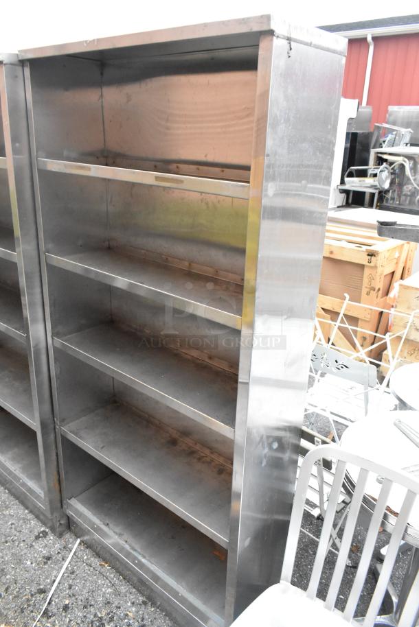 Stainless steel shelving unit, four shelves, used condition, rugged industrial design, ideal for storage or display.