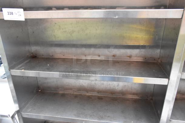 Stainless steel shelving unit with three shelves. Features visible wear and rust. Auction tag indicates quantity x2.