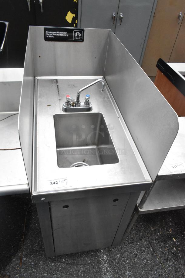 Stainless steel single bay sink with side splash guards, faucet, and handles; good condition with visible label on hygiene.