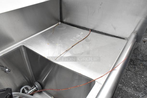 Stainless steel 3 bay sink with dual drain boards. Features multiple basins, integrated faucet, and some visible scratches. Ideal for commercial use.