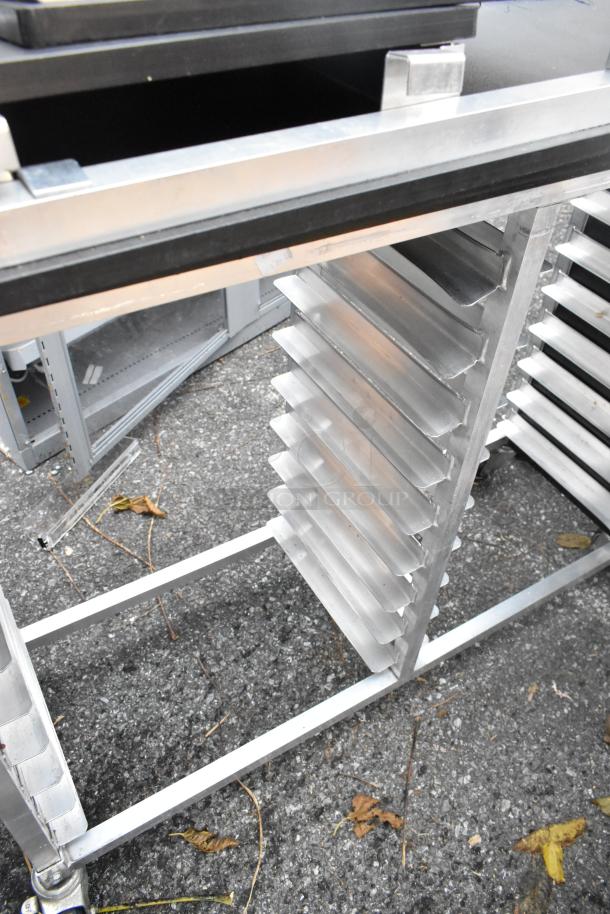 2 metal double pan transport racks with commercial casters, shown outdoors, featuring multiple shelves in good condition.