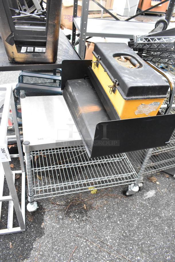 Wire 2-tier shelving unit on commercial casters, includes contents. Features sturdy wire design, light wear visible.