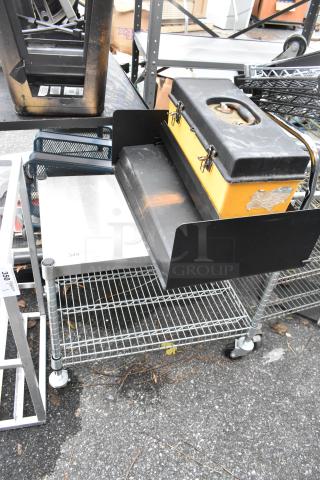 Wire 2-tier shelving unit on commercial casters, includes contents. Features sturdy wire design, light wear visible.