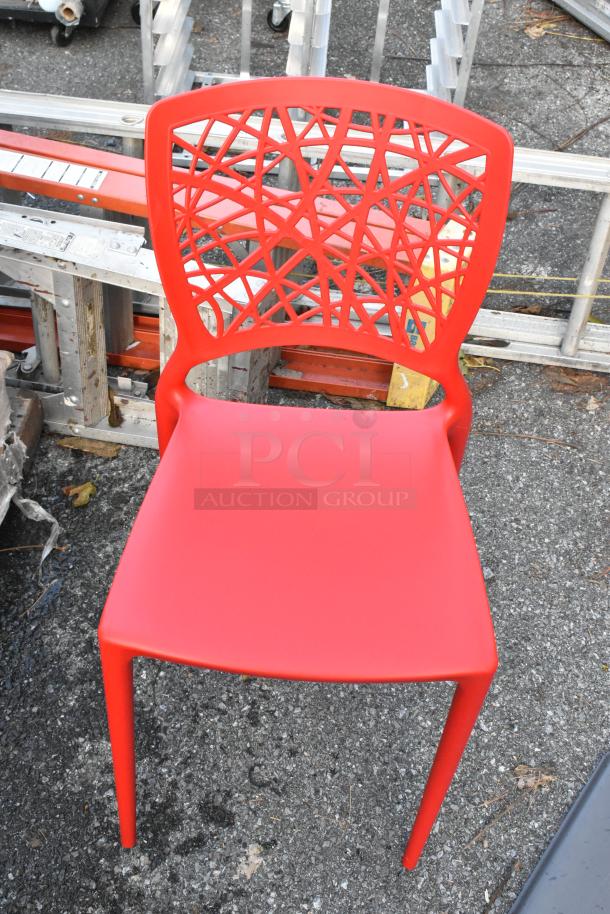 Red poly dining chair with geometric back design, brand new with minor scratches. Auction lot includes 18 chairs.