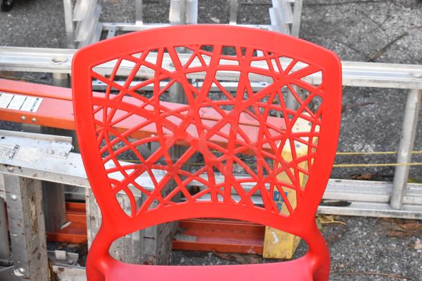 Red poly dining height chair with geometric cutout design, in brand new scratch and dent condition.