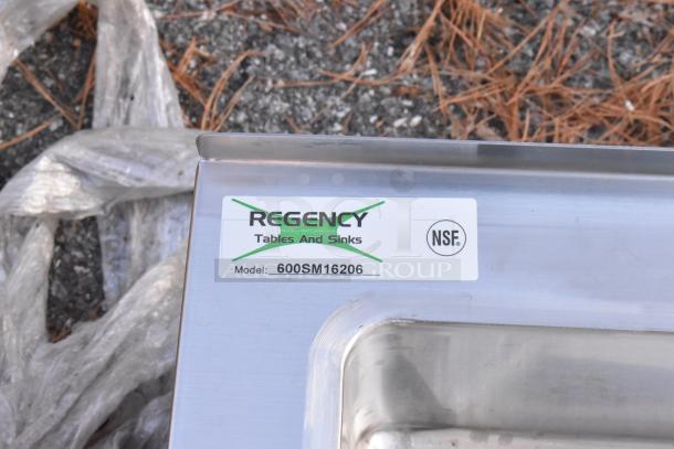 Brand new Regency 600SM16206 stainless steel mop sink, 25" with 20"x16"x6" bowl. Scratch and dent condition. NSF certified label visible.