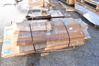 Stack of boxed "scratch and dent" items including Regency stainless steel shelves and Cambro serving trays. Boxes slightly damaged.