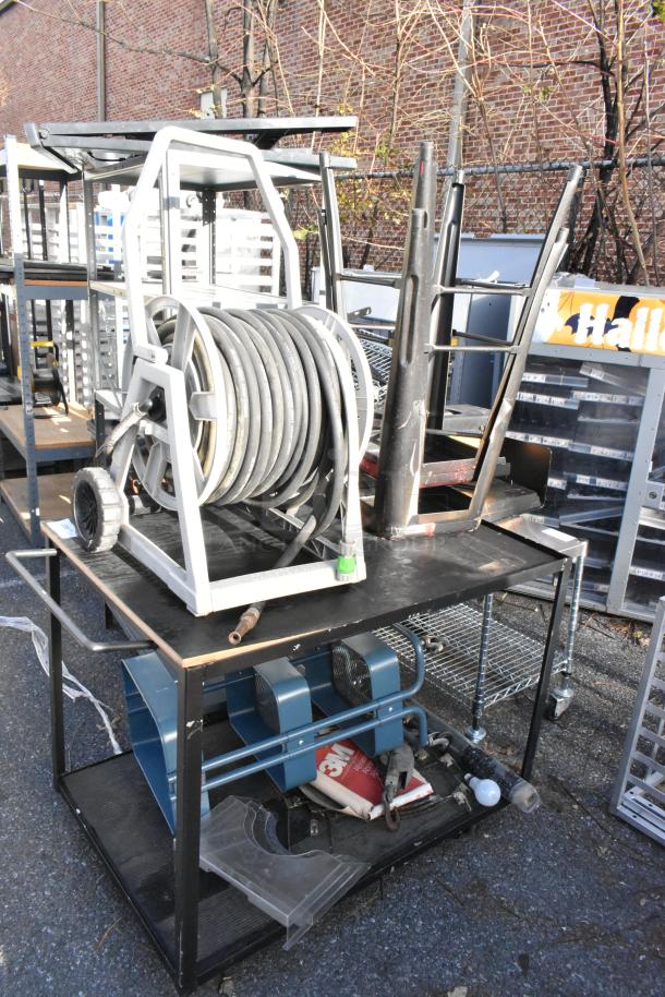 Cart with hose on reel, bar stools, and miscellaneous contents. Visible wear, ideal for garage or workshop use.