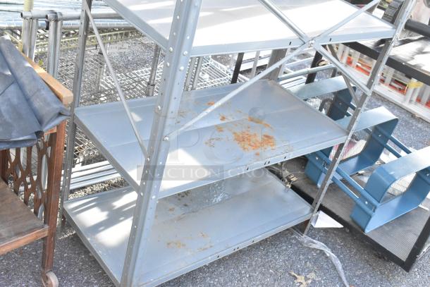 Gray metal shelving unit with rust spots and wooden two-tier cart on casters, auction lot featuring three items.