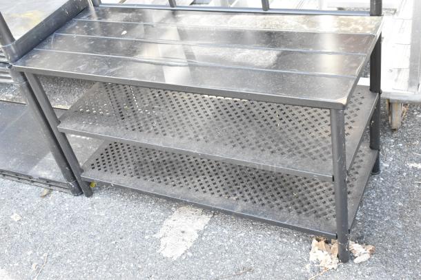 Black metal shoe rack with coat hanging rack; three perforated shelves, sturdy metal construction, visible wear.