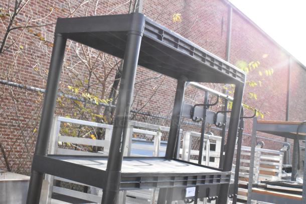 Black 5 tier poly shelving unit, sturdy construction, ideal for storage, minimal wear, outdoor auction setting.
