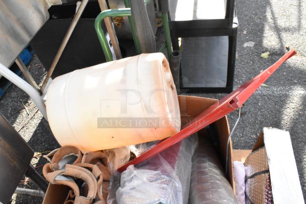 Flat cart loaded with miscellaneous items, including a white barrel, red metal bar, and various packaged goods. Items appear used.