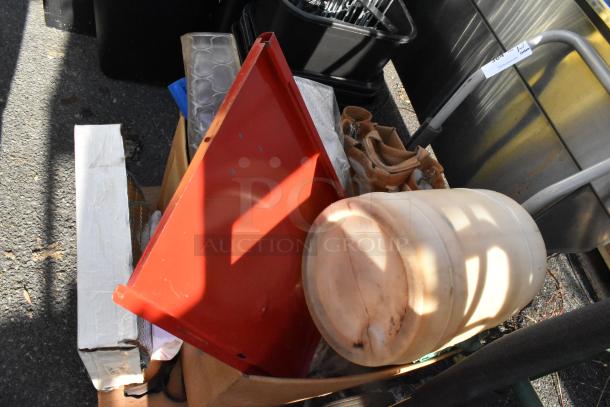 Flat cart with assorted contents including a red metal sheet, white container, and various boxes. Moderate wear visible.