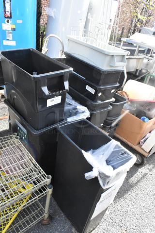 16 various poly trash cans in black, different sizes, some with lids. Label indicates 365 lb capacity. Good condition.