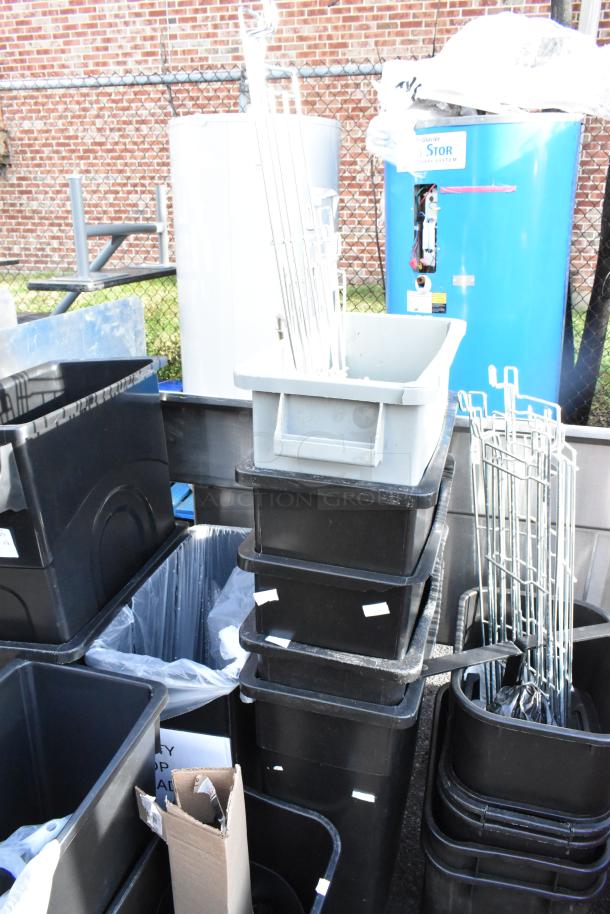 16 various poly trash cans, stacked outdoors. Includes both black and gray bins, all in used condition.
