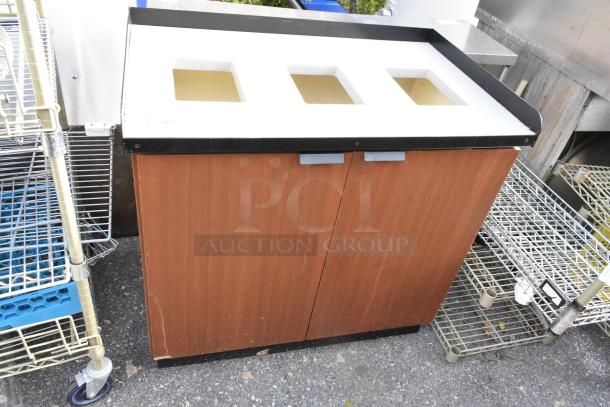 Wood-patterned trash can shell with three deposit holes and two front doors, showing mild wear.