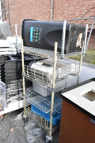Wire shelving unit with commercial casters, includes trash can and assorted items. Buyer must dismantle. Consider freight charges.