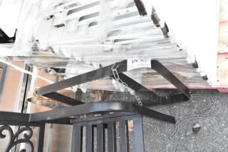 Black metal pot rack, robust construction, features attachable chains for hanging. Condition appears lightly used. Auction label visible.