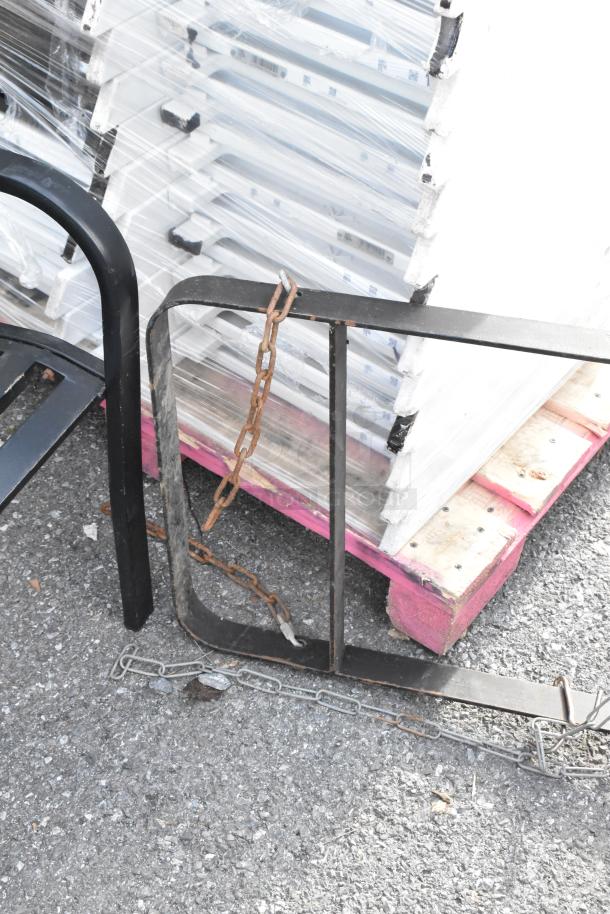 Black metal pot rack with chain, showing signs of rust. Suitable for kitchen or storage use, in fair condition.