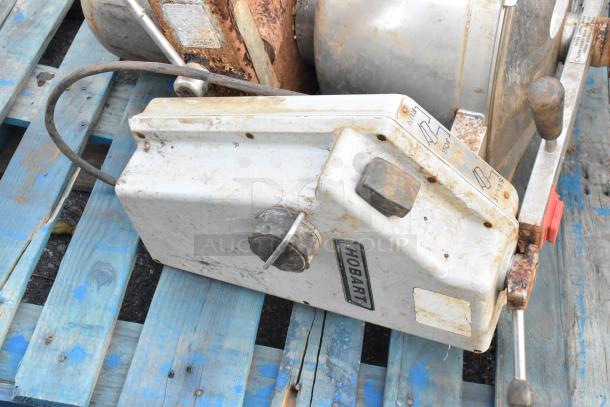 Hobart cutter mixer on blue pallet, showing signs of rust and wear. Visible Hobart label and control panel with function markings.