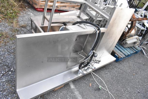 Stainless steel single bay L-shaped sink, featuring industrial-grade construction and dual faucets. Used condition.