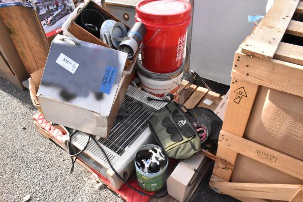 Pallet lot containing various items like dishes, bins, and a red bucket marked "Paint Thinner." Items include metal and plastic materials.