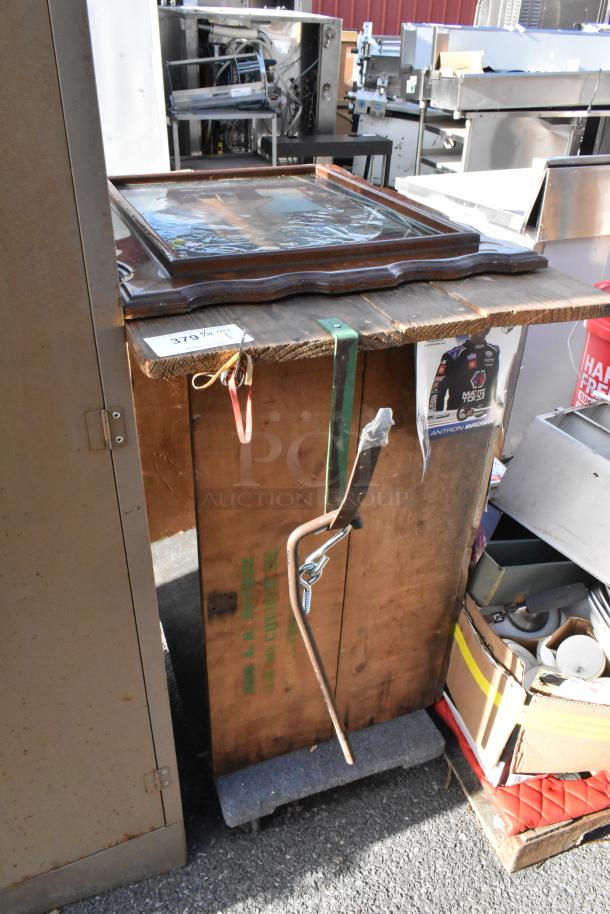 Wooden table with a rustic finish, visible wear, and an ornate wooden frame on top. Label "379½" attached.