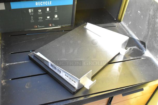 Wooden counter with four doors, includes scattered contents. Visible barcode and recycle guide on black panel. Good condition.