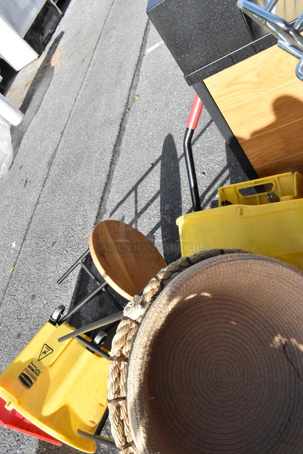 Pallet lot with various items including trash cans, a cart, a wooden stool, and a woven basket. Good condition.