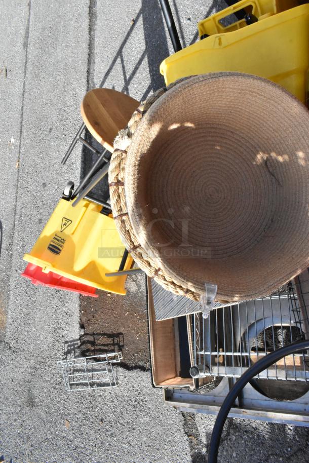 Pallet lot with various items including yellow trash cans, a woven basket, a cart, and miscellaneous metal items.