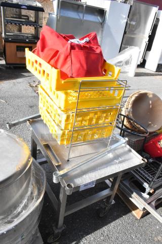 Metal table on commercial casters, includes yellow containers and red bag. Sturdy condition; ideal for industrial use.