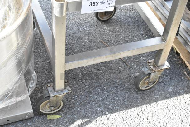 Metal table on commercial casters, sturdy frame with a tag marked "383 w/ contents," showing light wear.