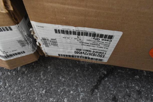 Cardboard boxes with labels showing items including Cambro ESU183672V4580 Shelving Unit and Adcraft ES-2448 Stand.