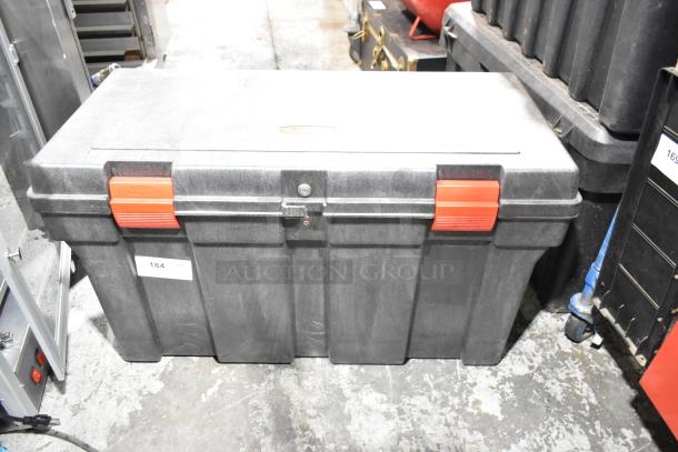 Black plastic tool box with red latches and a central lock, containing contents. Label reads "184." Durable and spacious design.