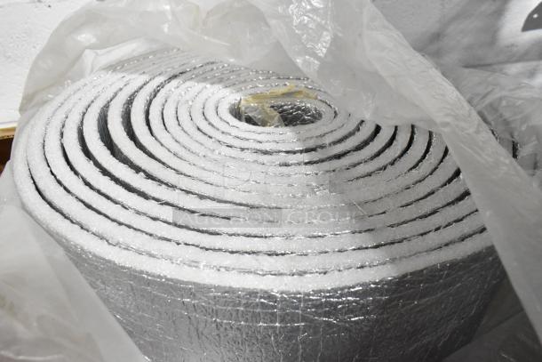 Roll of silver-colored insulated material, wrapped in plastic, unused, ideal for temperature control applications.