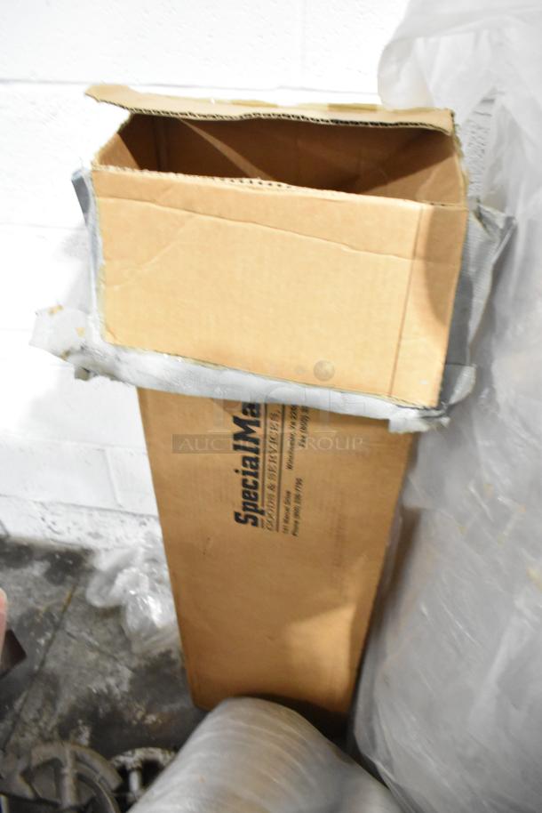Cardboard box labeled "SpecialMade," containing assorted items like insulated rolls and a wet floor sign, in used condition.
