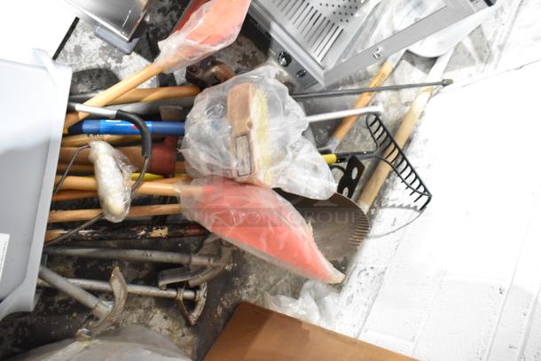 Gray Slim Jim trash can containing 20 various items, including a rake, broom, and shovel, wrapped in plastic.