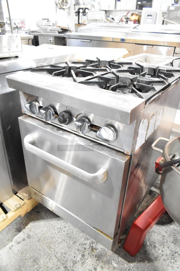 Stainless steel commercial 4-burner gas range with oven; used condition, visible dials, sturdy design.