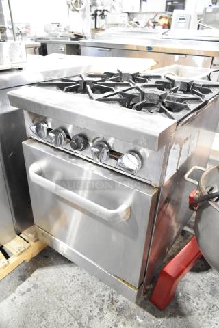 Stainless steel commercial 4-burner gas range with oven; used condition, visible dials, sturdy design.