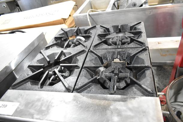 Stainless steel commercial gas 4-burner range with oven, good condition, sturdy cast iron grates, model label "259" visible.
