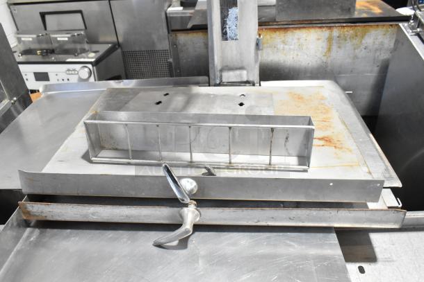 Metal commercial floor-style meat saw, stainless steel finish, showing some rust and wear. Suitable for heavy-duty use.