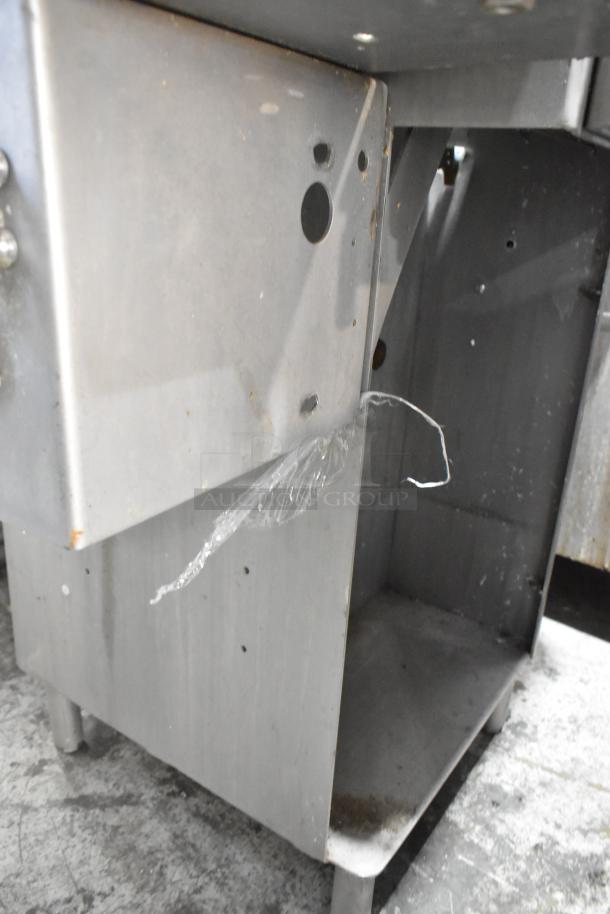 Metal commercial floor-style meat saw, stainless steel, visible wear, sturdy frame, ideal for heavy-duty use.
