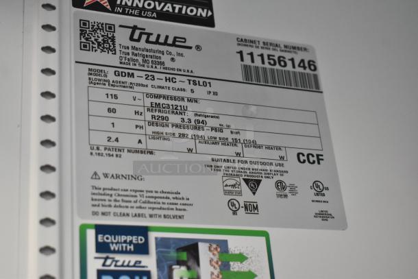 Label on True GDM-23-HC cooler showing model details, refrigerant type R290, 115V, 1 phase, with warning and certification marks.
