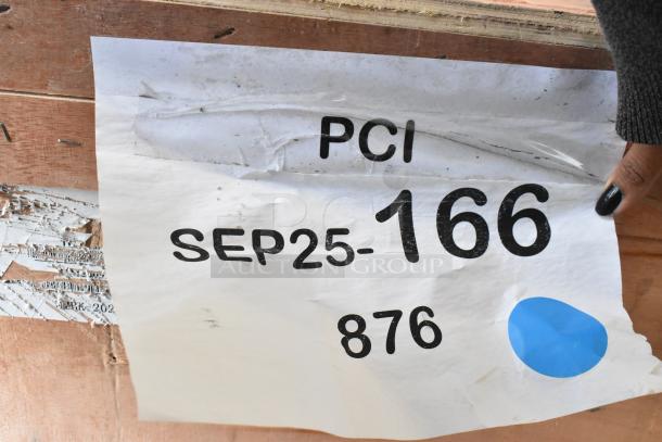 Brown wooden crate with a damaged white label reading "PCI SEP25-166 876," partially torn and worn.