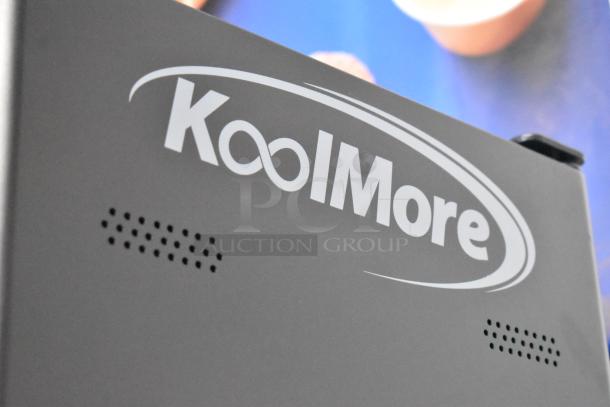 Brand new KoolMore metal commercial vending machine, black, with visible logo. Scratch and dent condition.