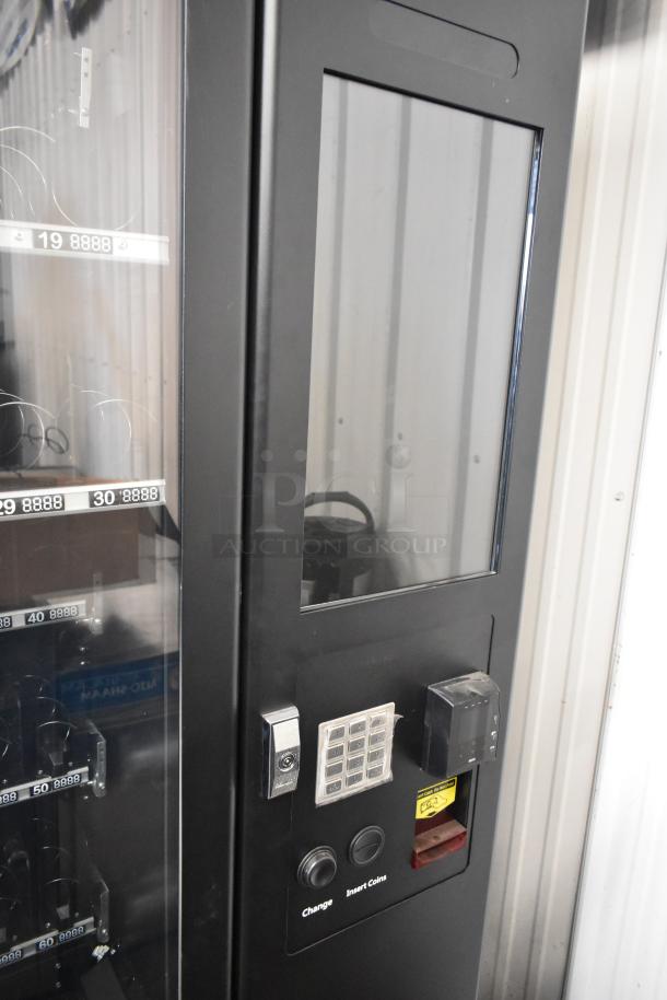 KoolMore metal vending machine, brand new with scratches and dents. Features keypad, coin insert, and product spirals.