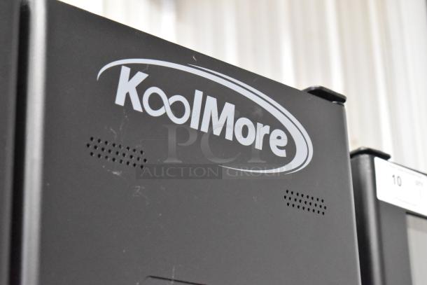 Brand new KoolMore metal commercial vending machine, visible scratches, and dents, KoolMore logo displayed on the side.