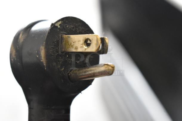 Close-up of a power plug from a 2018 True T-23F-HC commercial freezer, showing worn prongs and minor discoloration.