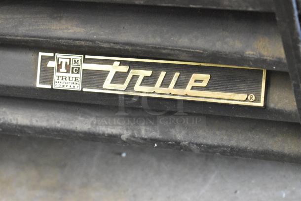 True GDM-45 metal cooler logo, gold lettering on a black background, indicating the brand and model.